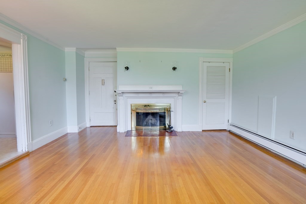 156 Chestnut Street, Unit 6 North Andover, MA 01845 - Photo 4 of 27 a view of an empty room with wooden floor fireplace and a window