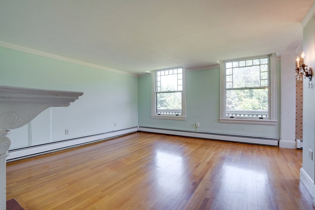156 Chestnut Street, Unit 6 North Andover, MA 01845 - Photo 6 of 27 an empty room with wooden floor and windows