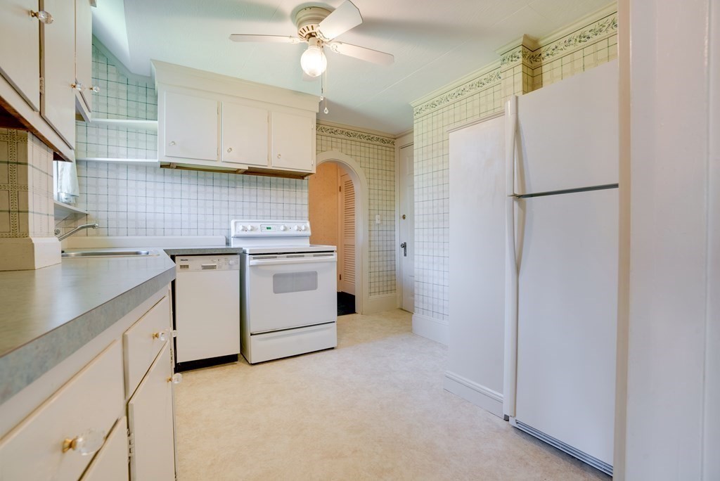 156 Chestnut Street, Unit 6 North Andover, MA 01845 - Photo 9 of 27 a kitchen with a sink a refrigerator a stove and cabinets