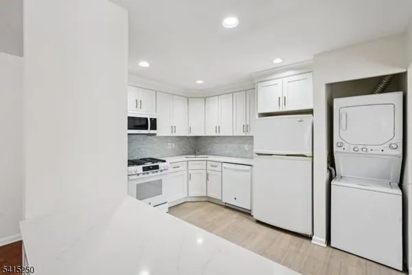 a kitchen with stainless steel appliances kitchen island granite countertop a sink and refrigerator