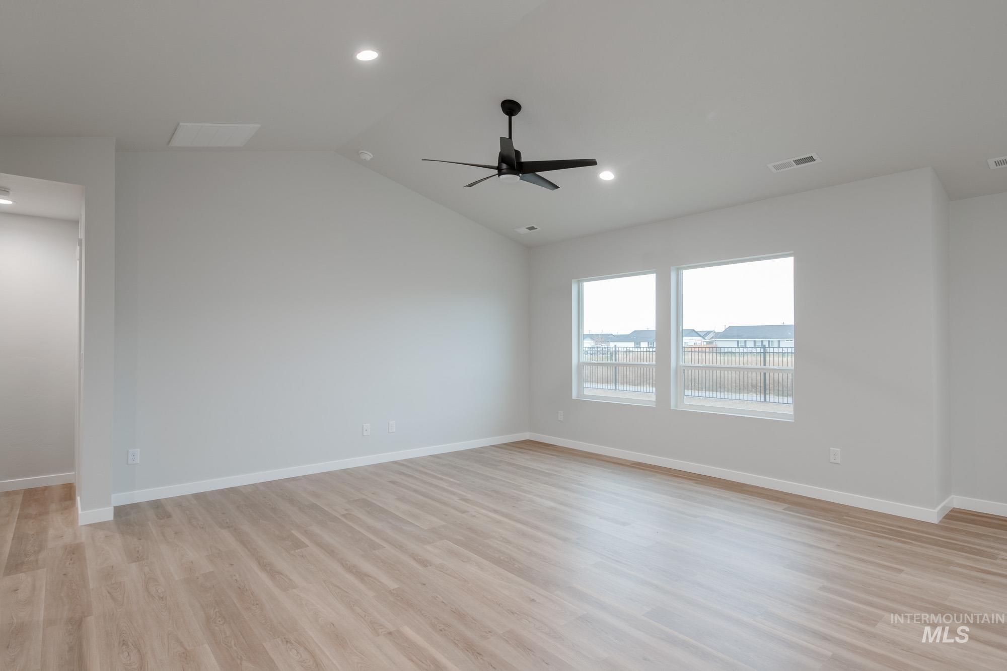 16730 Dunning Way Caldwell, ID 83607 - Photo 10 of 22 Unfurnished room featuring lofted ceiling, light wood-style floors, a ceiling fan, and recessed lighting