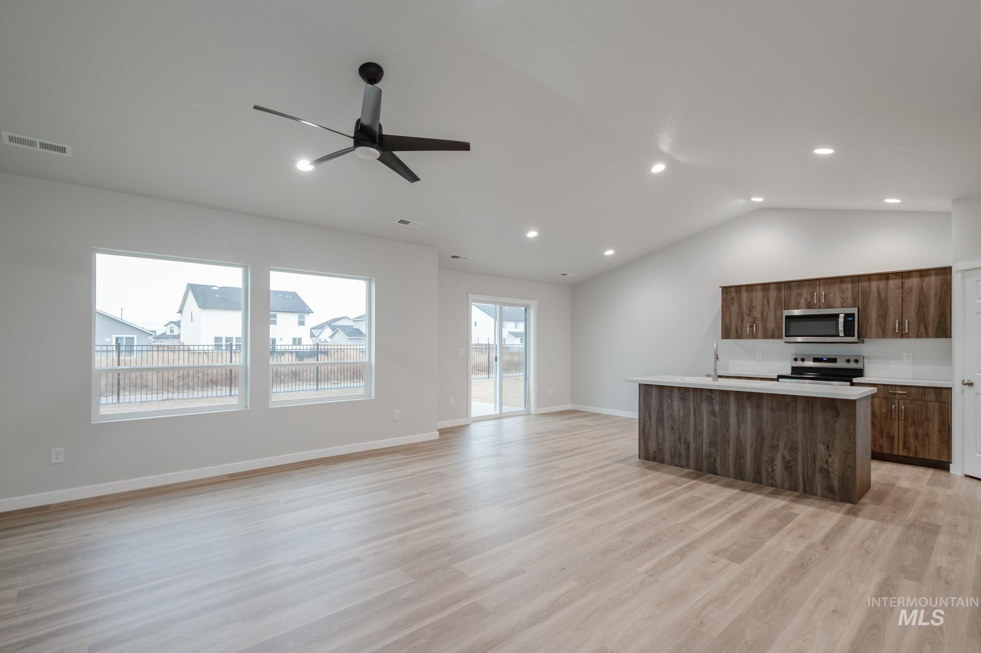 16730 Dunning Way Caldwell, ID 83607 - Photo 20 of 22 Kitchen with an island with sink, open floor plan, lofted ceiling, stainless steel appliances, and light wood-type flooring
