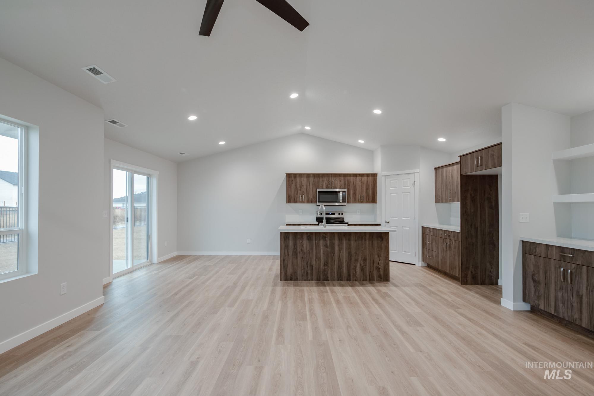 16730 Dunning Way Caldwell, ID 83607 - Photo 21 of 22 Kitchen with a center island with sink, lofted ceiling, light wood-style flooring, a ceiling fan, and open floor plan