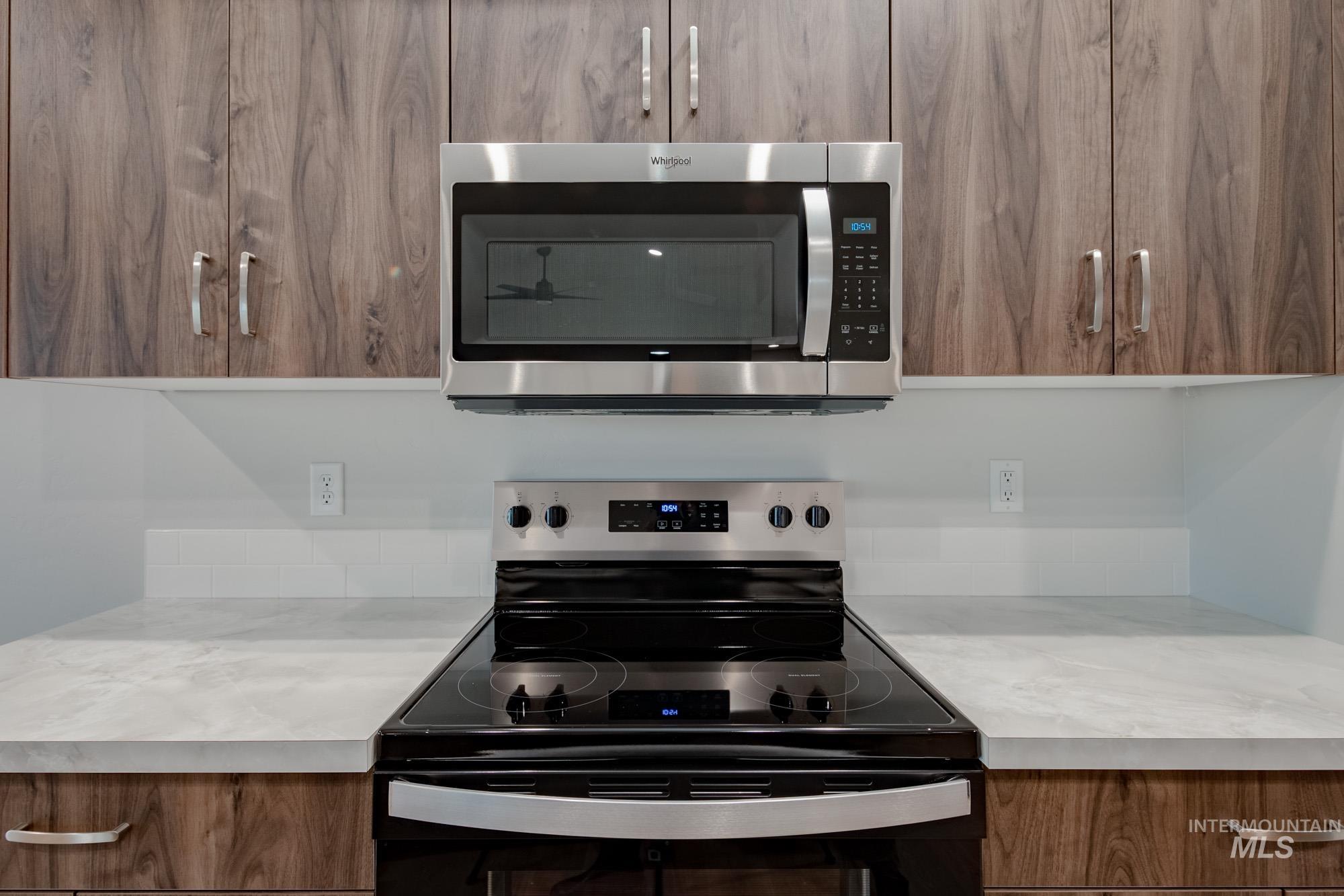 16730 Dunning Way Caldwell, ID 83607 - Photo 4 of 22 Kitchen with black / electric stove, stainless steel microwave, modern cabinets, and brown cabinets