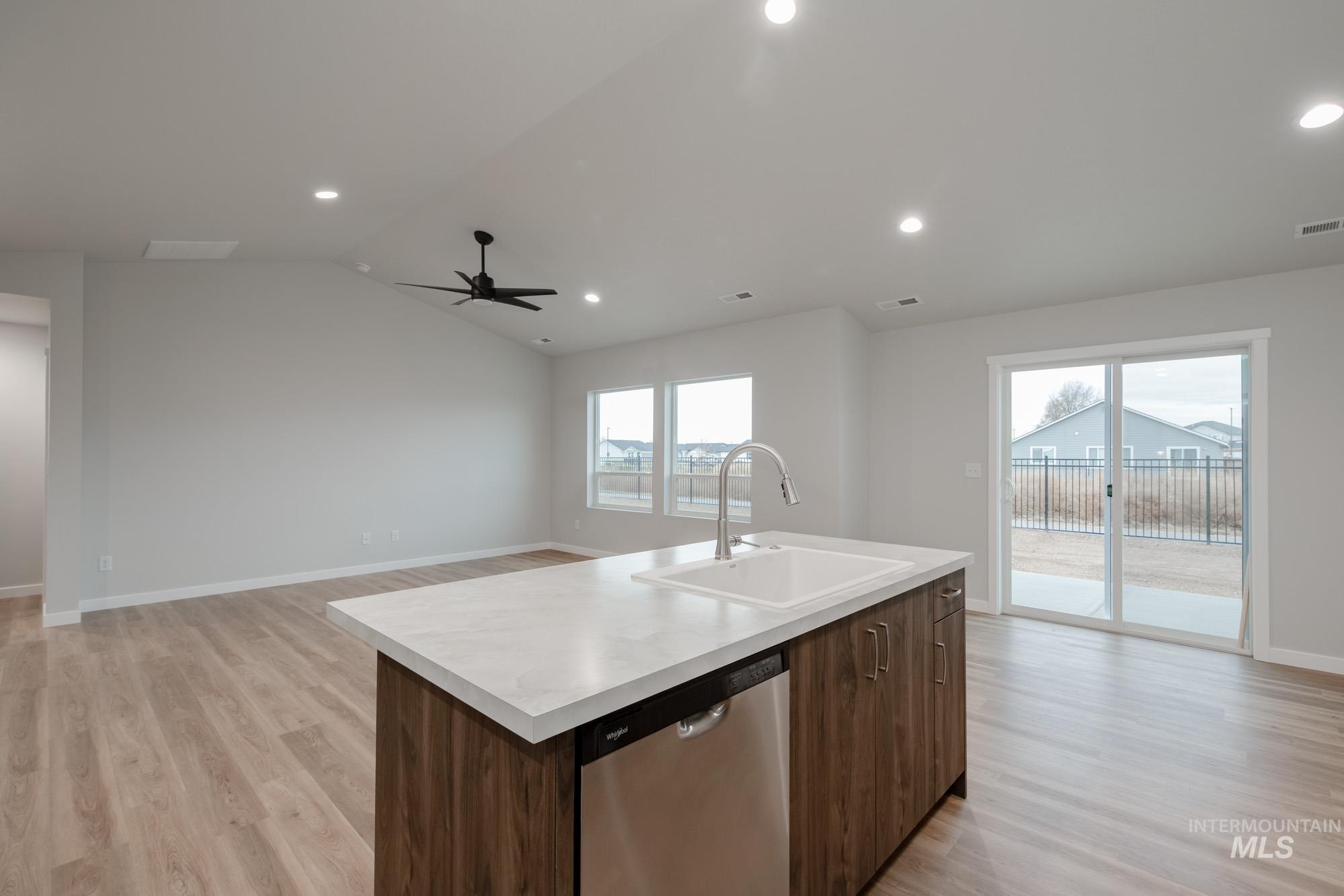 16730 Dunning Way Caldwell, ID 83607 - Photo 19 of 22 Kitchen featuring light countertops, open floor plan, dishwasher, light wood-style floors, and vaulted ceiling
