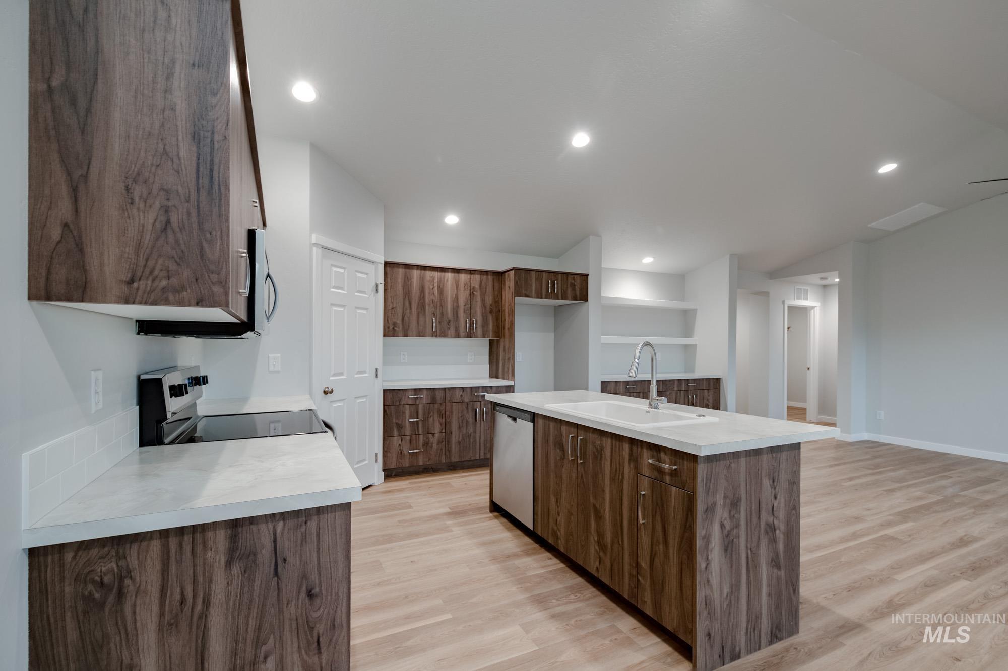 16730 Dunning Way Caldwell, ID 83607 - Photo 7 of 22 Kitchen with appliances with stainless steel finishes, light wood-style floors, a kitchen island with sink, recessed lighting, and open shelves