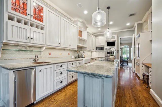 a kitchen with cabinets and wooden floor