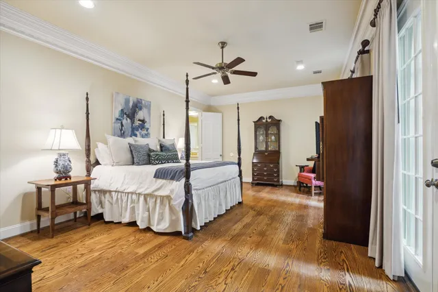a spacious bedroom with a bed a table and painting on the wall