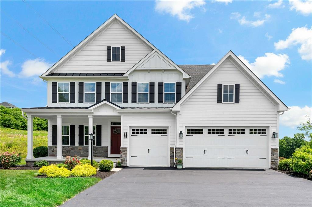 a view of a white house with a big yard and potted plants in front of it