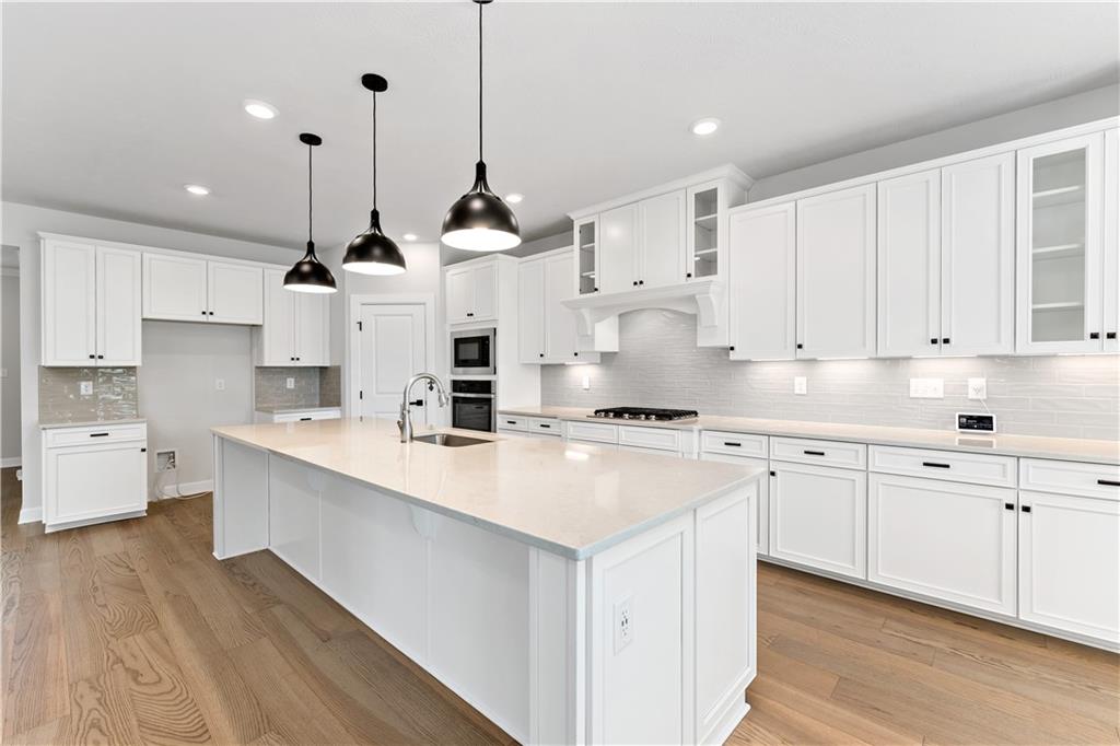 107 Abigail Drive Mars, PA 16046 - Photo 7 of 50 a kitchen with stainless steel appliances sink stove and white cabinets with wooden floor