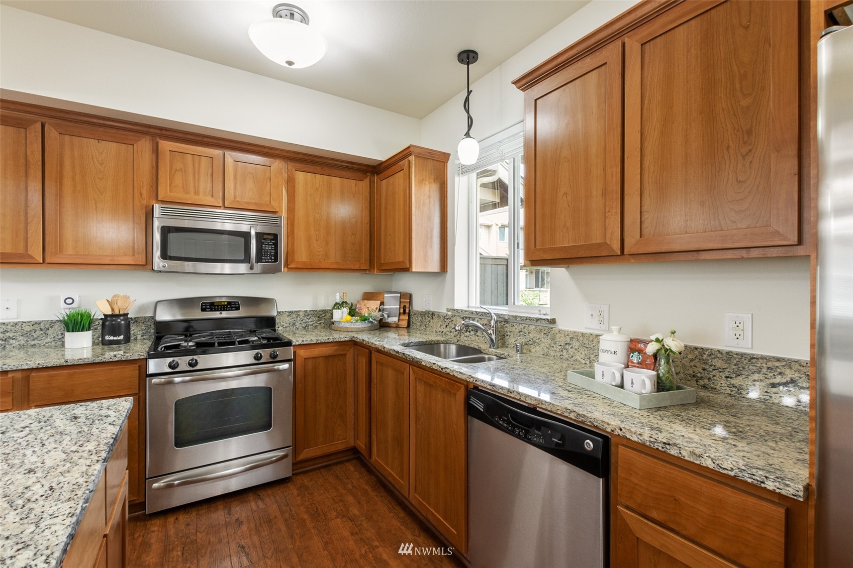 320 Chelan Place Northeast, Unit H4 Renton, WA 98059 - Photo 12 of 25 a kitchen with stainless steel appliances granite countertop wooden cabinets a stove top oven a sink and dishwasher