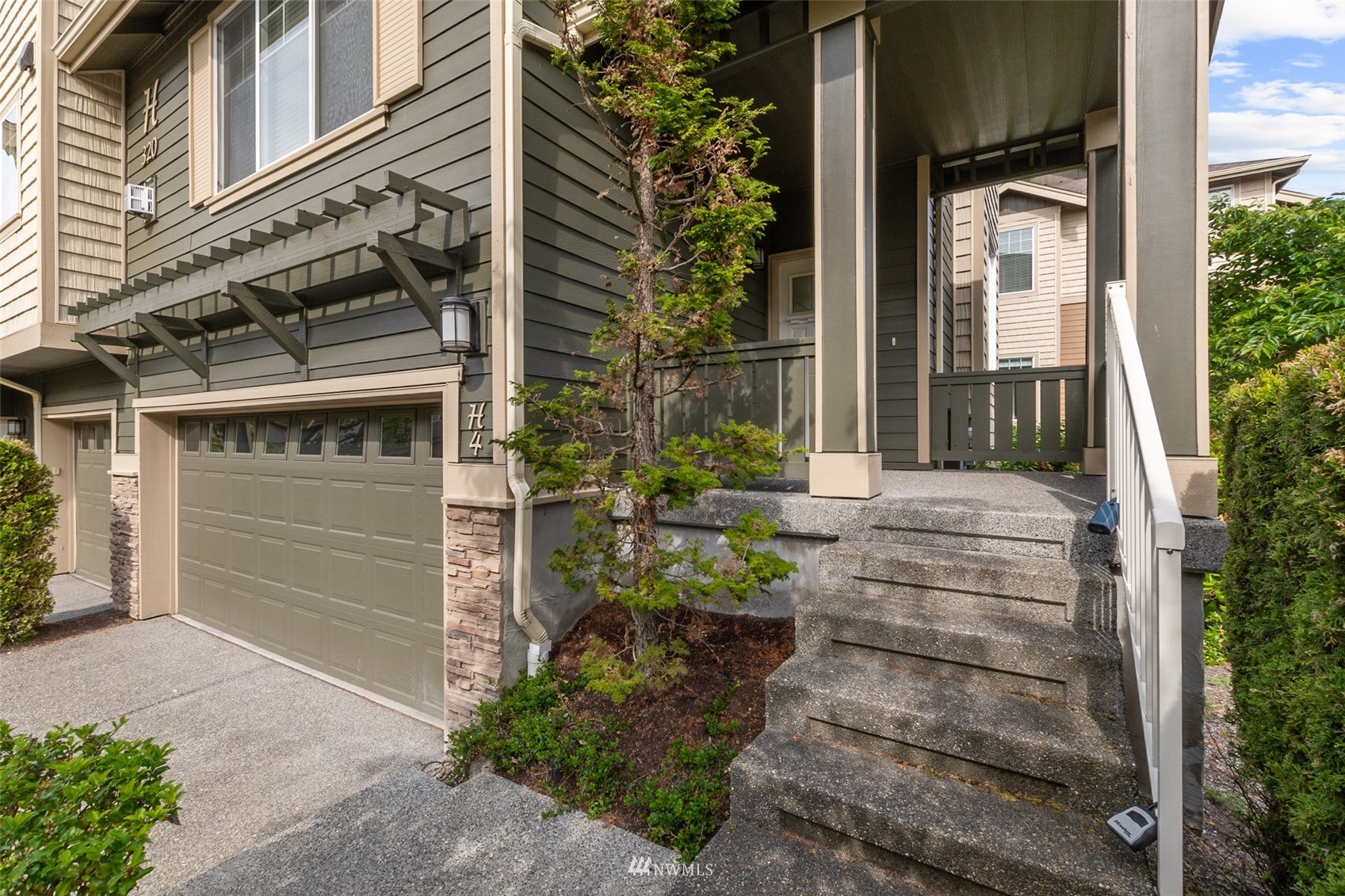 320 Chelan Place Northeast, Unit H4 Renton, WA 98059 - Photo 3 of 25 front view of a house with a potted plant and floor to ceiling windows