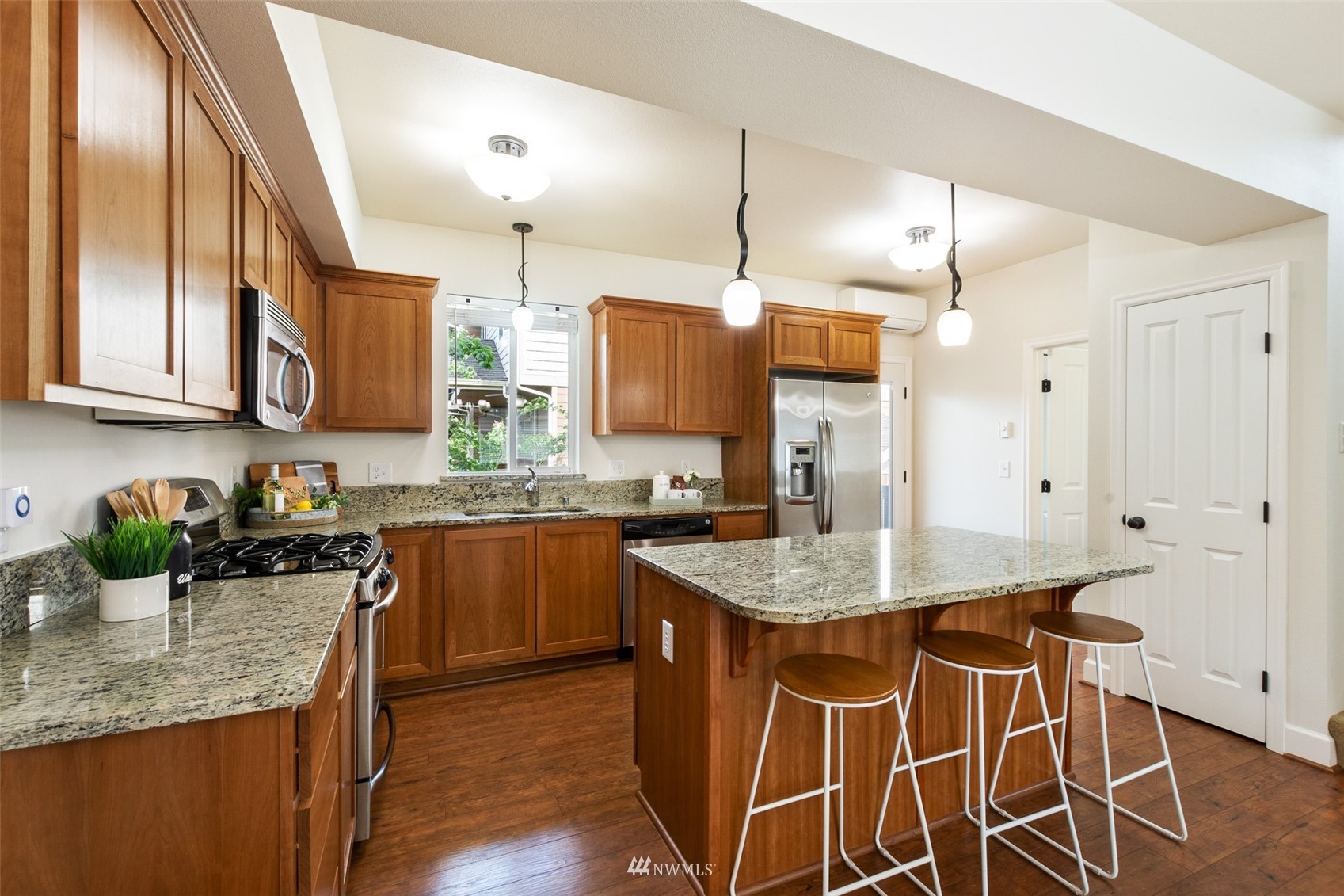 320 Chelan Place Northeast, Unit H4 Renton, WA 98059 - Photo 10 of 25 a kitchen with stainless steel appliances granite countertop wooden cabinets a stove top oven a sink and dishwasher