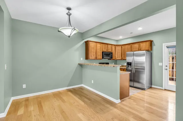 a kitchen with granite countertop stainless steel appliances a refrigerator stove top oven and sink