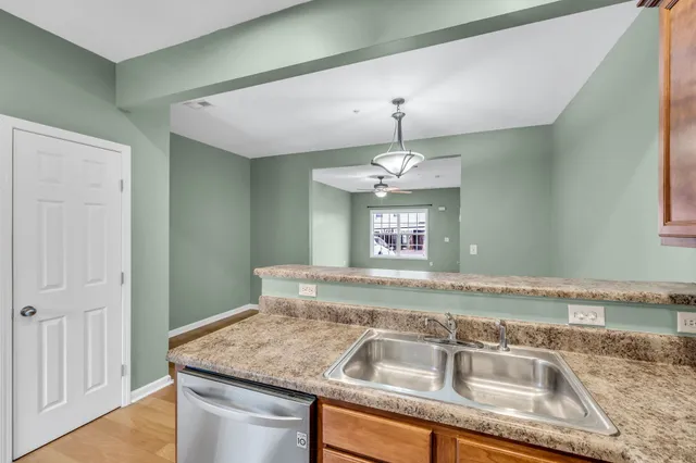 an empty room with wooden floor and a ceiling fan