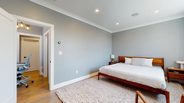 a bedroom with a bed and wooden floor