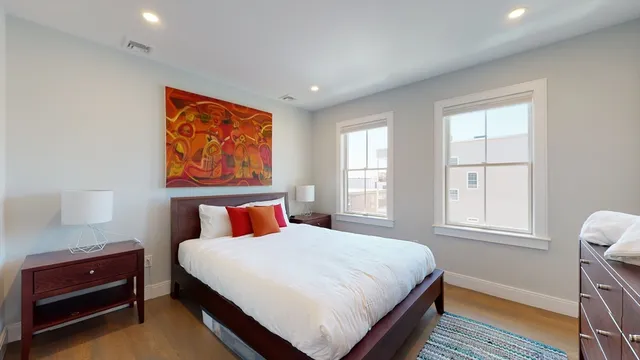 a bedroom with a bed and wooden floor