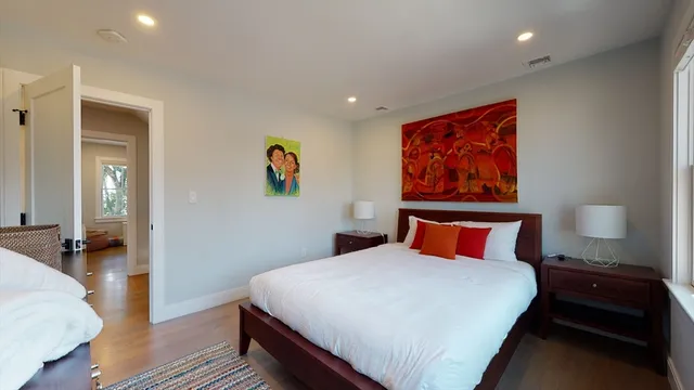 a bedroom with a bed and wooden floor