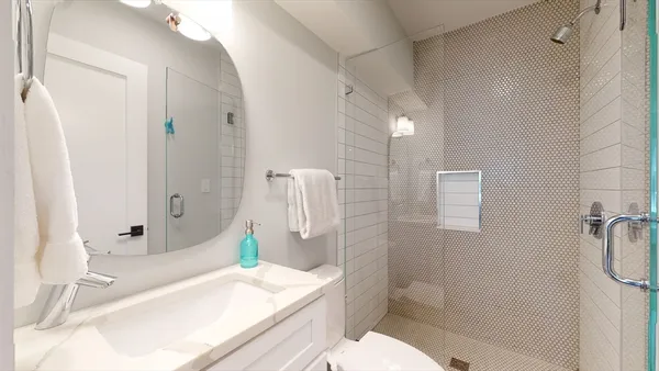 a bathroom with a sink a toilet and shower