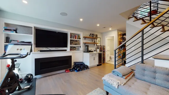 a living room with furniture a flat screen tv and a fireplace