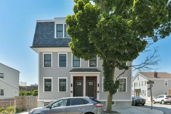 a front view of a residential apartment building with a yard