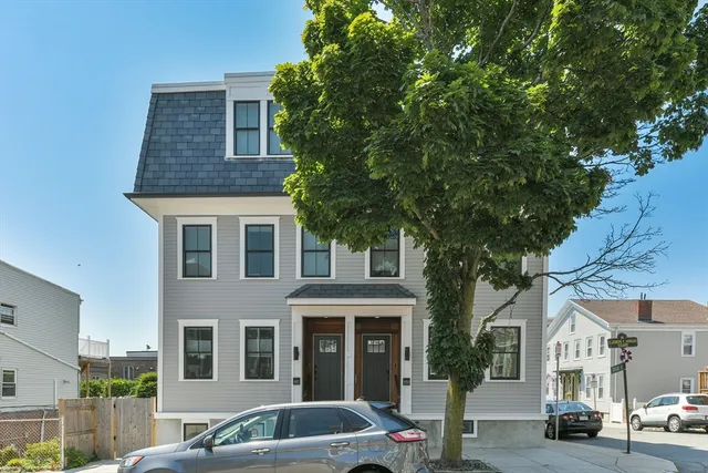a front view of a residential apartment building with a yard