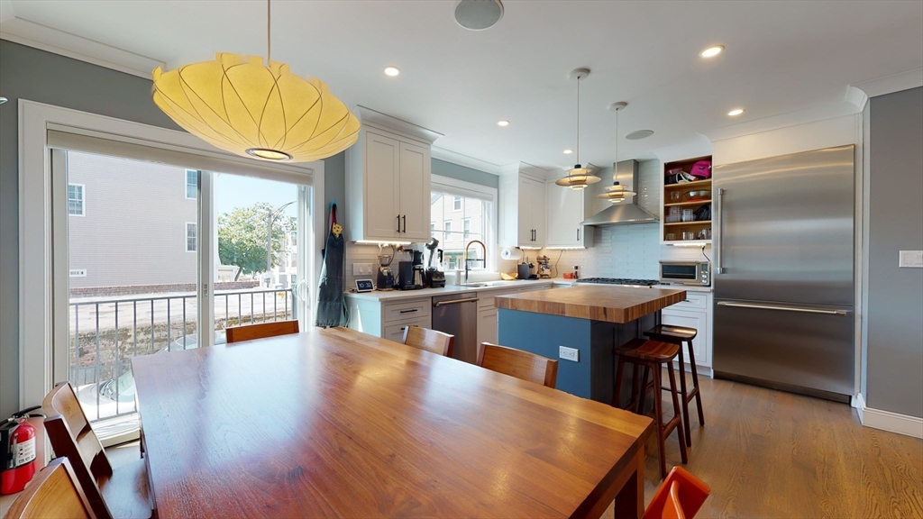459 East 8th Street, Unit 1 Boston, MA 02127 - Photo 6 of 31 a kitchen with stainless steel appliances granite countertop a refrigerator a sink a stove and white cabinets with wooden floor