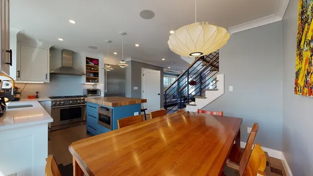 a kitchen with stainless steel appliances granite countertop a stove top oven a sink with the island stainless steel appliances and cabinets