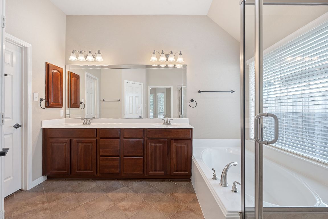 1809 Cross Draw Trail Leander, TX 78641 - Photo 15 of 22 a spacious bathroom with a double vanity sink a large mirror and a bathtub