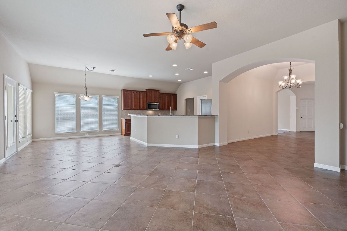 1809 Cross Draw Trail Leander, TX 78641 - Photo 4 of 22 a view of a kitchen with a stove cabinets a ceiling fan and wooden floor