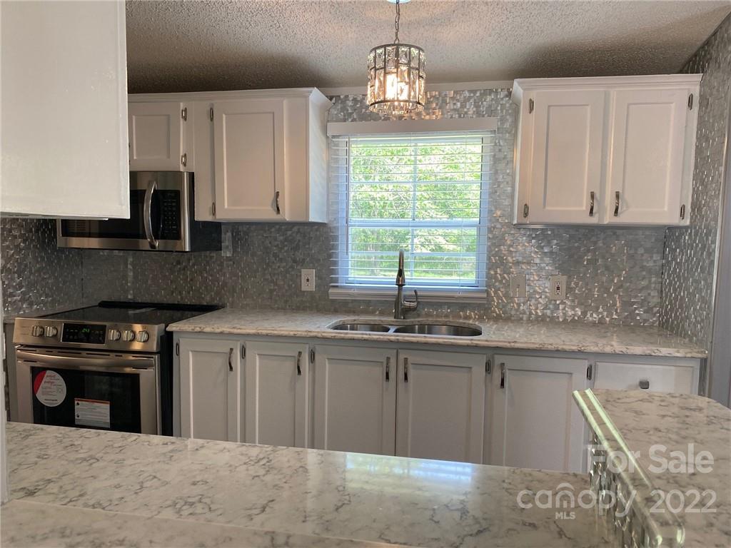 3283 Rhyner Road Lancaster, SC 29720 - Photo 4 of 35 a kitchen with stainless steel appliances granite countertop a sink stove and refrigerator