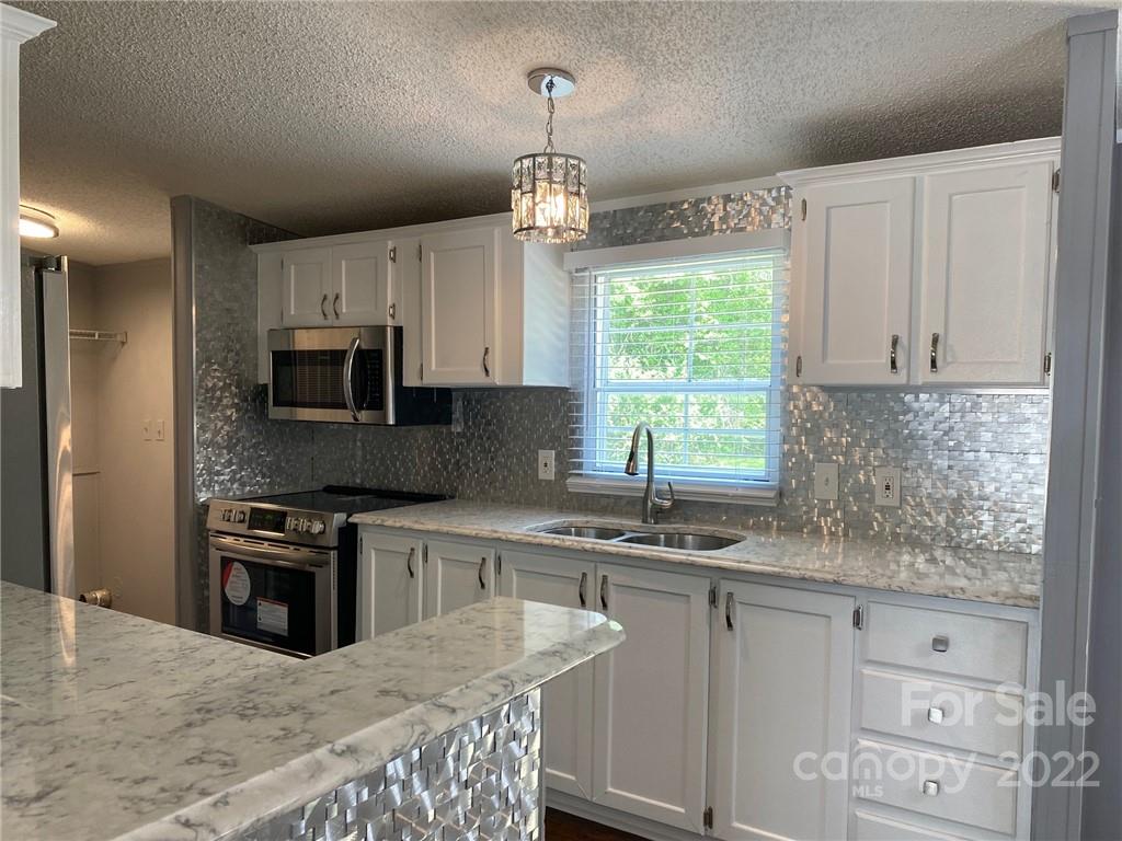 3283 Rhyner Road Lancaster, SC 29720 - Photo 7 of 35 a kitchen with stainless steel appliances granite countertop a kitchen island hardwood floor sink stove and granite counter top