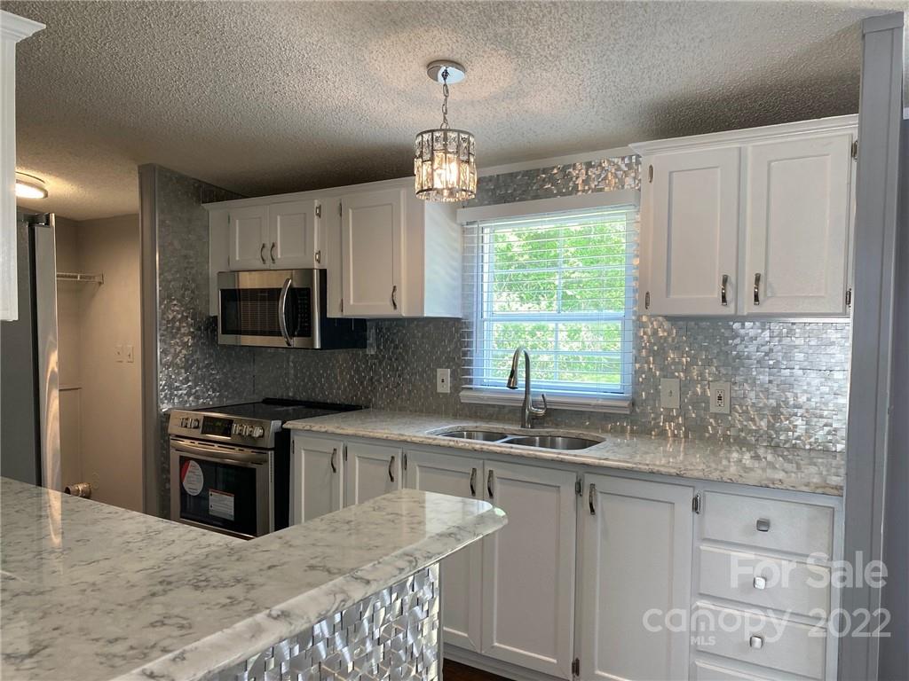 3283 Rhyner Road Lancaster, SC 29720 - Photo 8 of 35 a kitchen with stainless steel appliances granite countertop a kitchen island hardwood floor sink stove and granite counter top