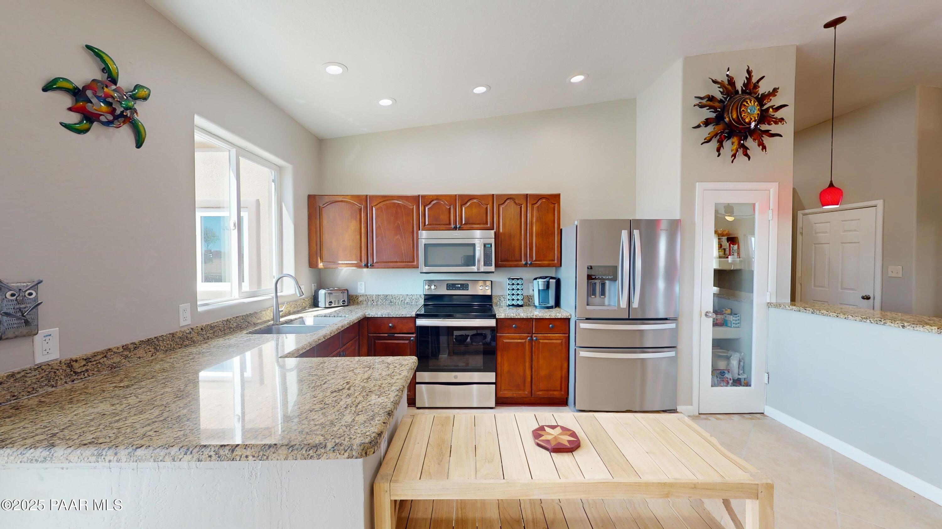 1780 South Yellow Brick Road Chino Valley, AZ 86323 - Photo 19 of 47 a kitchen with stainless steel appliances granite countertop a refrigerator sink and wooden cabinets