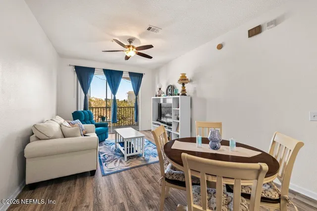 a living room with furniture a ceiling fan and a wooden floor