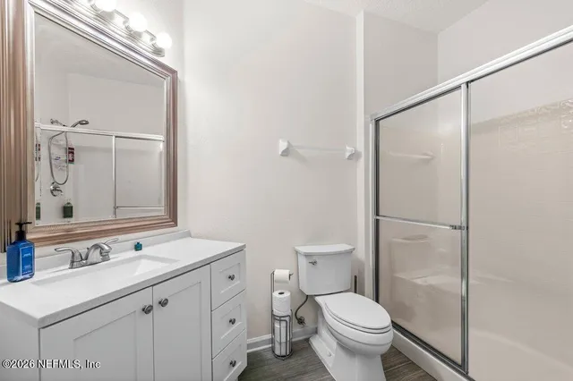 a bathroom with a shower a toilet and a glass door