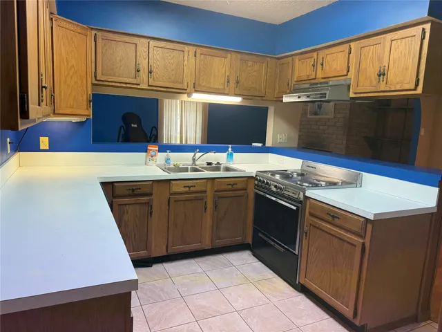 a kitchen with stainless steel appliances a stove a sink and a refrigerator
