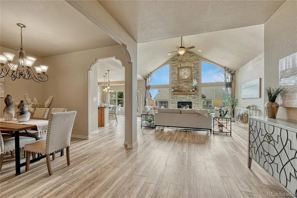 a view of a dining room with furniture a chandelier and wooden floor