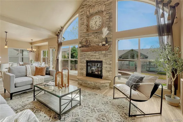 a living room with furniture a fireplace and a potted plant
