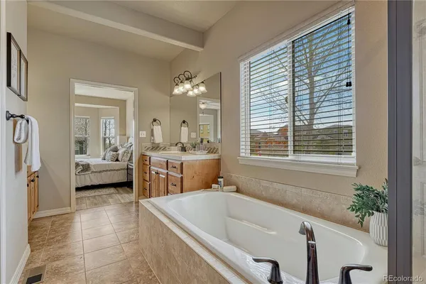 a bathroom with a tub a sink and a large mirror