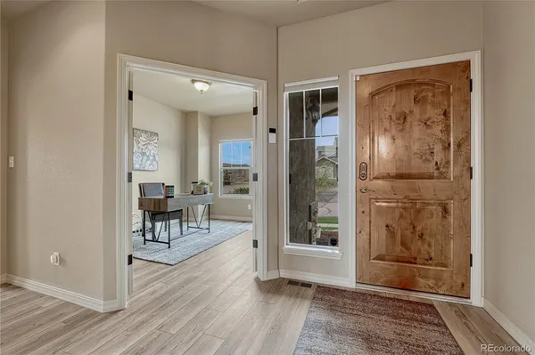a view of a hallway with wooden floor and a livingroom