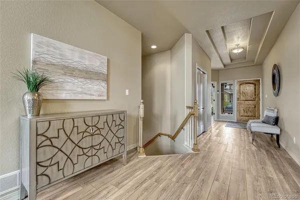 a view of a hallway with wooden floor and staircase