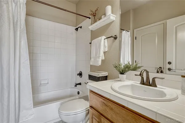 a bathroom with a granite countertop sink toilet and shower