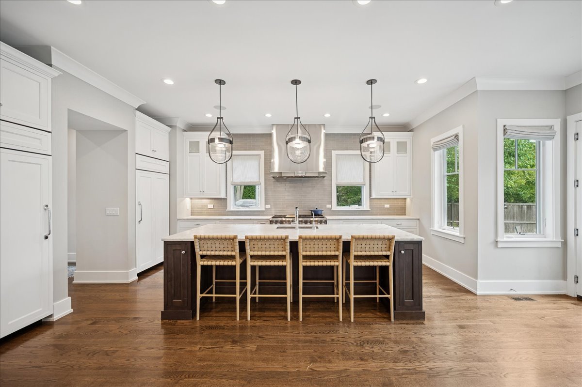 1004 Oak Street Winnetka, IL 60093 - Photo 14 of 51 a kitchen with stainless steel appliances granite countertop a stove top oven a sink dishwasher and a dining table with wooden floor