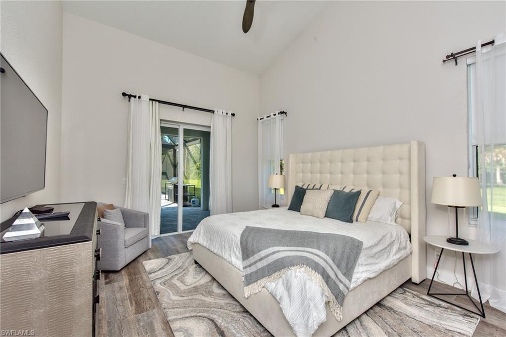 6106 Copper Leaf Lane Naples, FL 34116 - Photo 14 of 35 a bedroom with a bed and a lamp on table