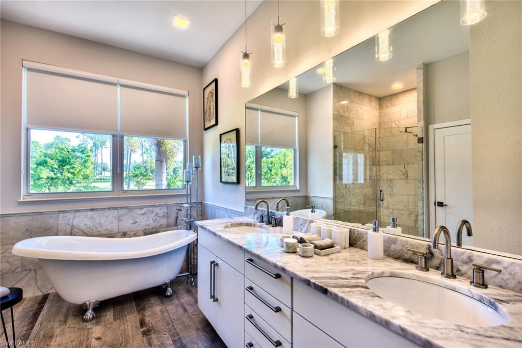 6106 Copper Leaf Lane Naples, FL 34116 - Photo 16 of 35 a bathroom with a granite countertop sink and a large mirror