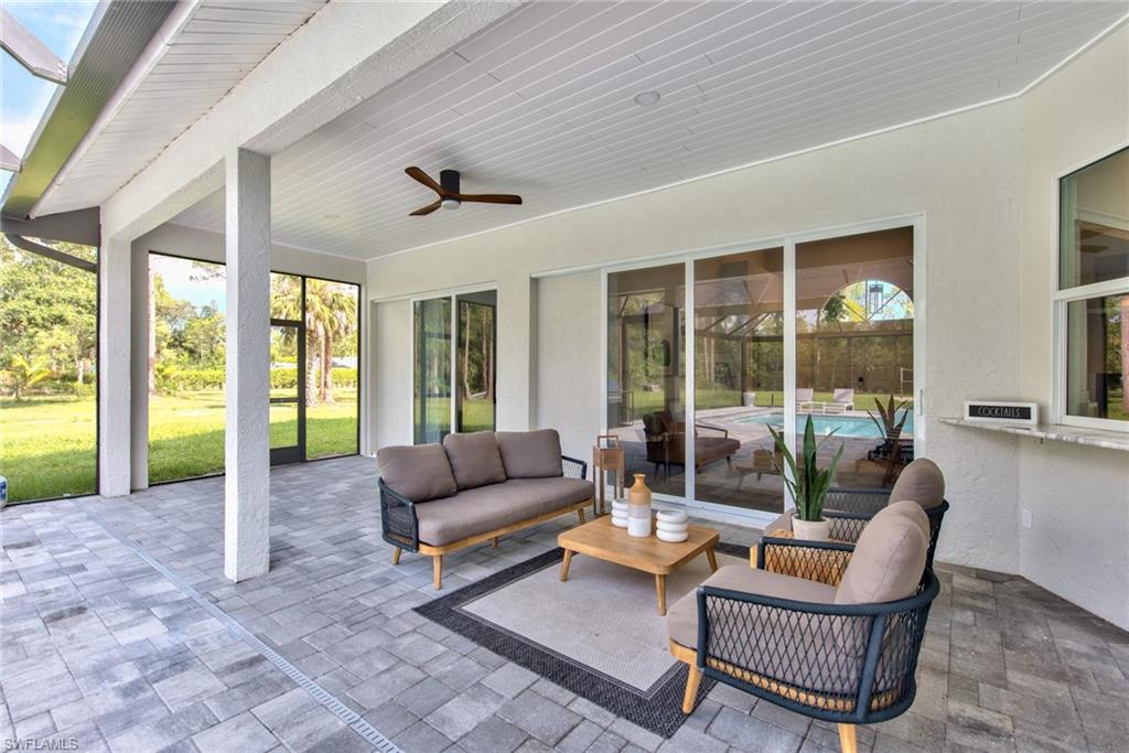 6106 Copper Leaf Lane Naples, FL 34116 - Photo 23 of 35 a living room with furniture and a floor to ceiling window