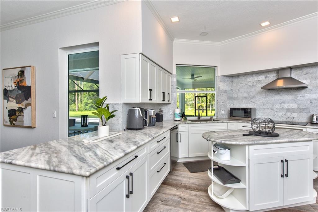 6106 Copper Leaf Lane Naples, FL 34116 - Photo 5 of 35 a kitchen with stainless steel appliances granite countertop a sink stove and cabinets