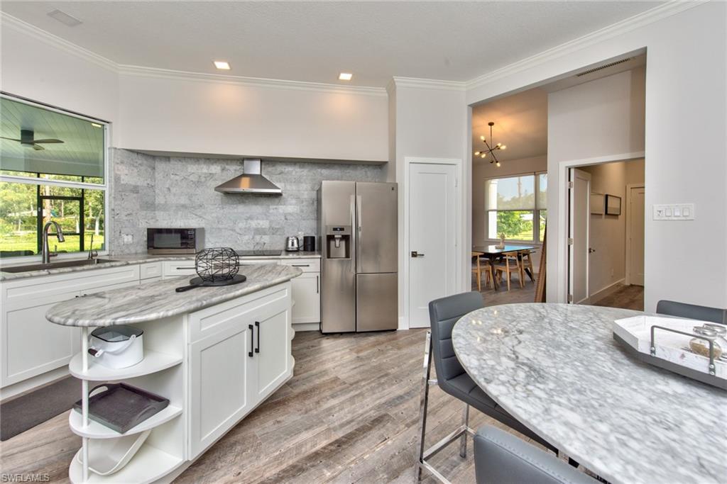 6106 Copper Leaf Lane Naples, FL 34116 - Photo 6 of 35 a large kitchen with a stove and a sink