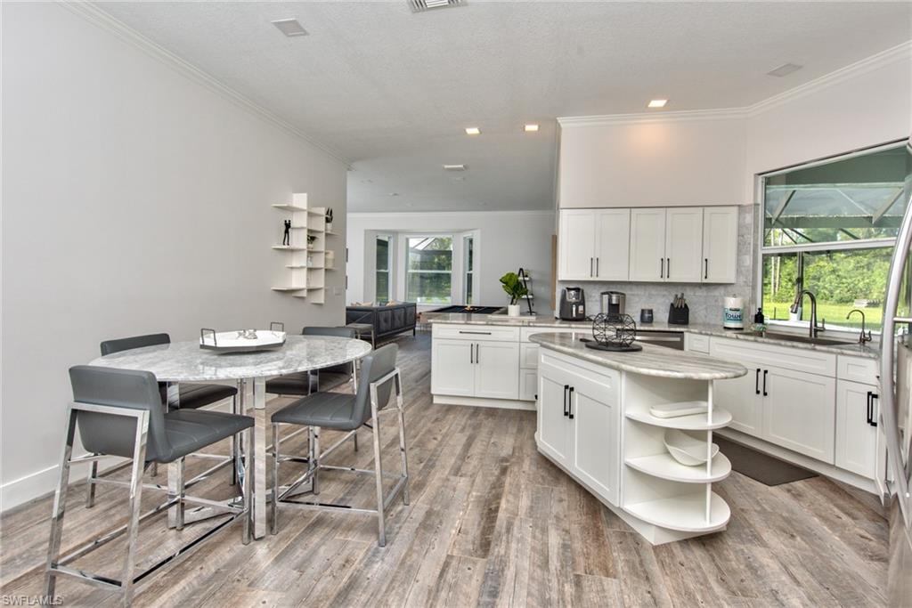 6106 Copper Leaf Lane Naples, FL 34116 - Photo 7 of 35 a kitchen with a dining table chairs and white appliances